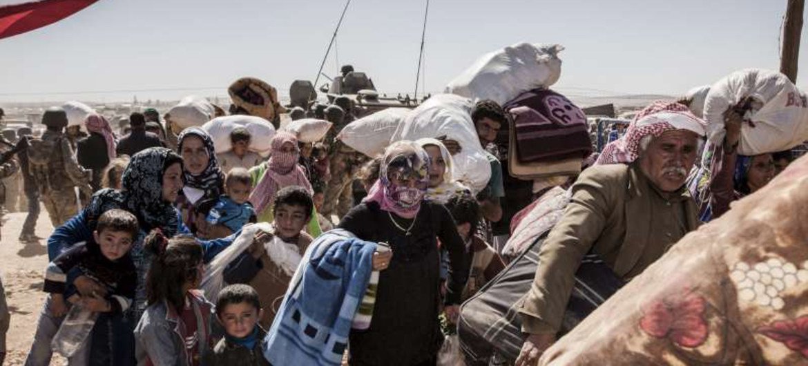 Syrian Kurdish refugees cross into Turkey from Syria near the town of Kobani.