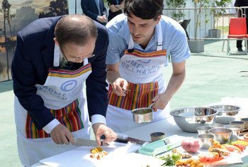 Secretary-General Ban Ki-moon (left) samples food prepared on fuel-efficient cook stoves at the UN Climate Change Conference in Lima, Peru.