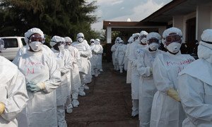 Health workers wearing personal protective equipment (PPE) outside a midwifery school where they are attending a training session on Ebola, in Makeni, Sierra Leone.