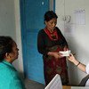 在尼泊尔农村，一位有经验的助产士正在与一位妇女交谈。世行图片/Aisha Faquir