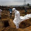 Une équipe de la Croix-Rouge transporte le corps d'un jeune homme, suspecté d'avoir été infecté par Ebola, pour l'enterrer. Photo ONU/Martine Perret