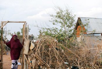 A displaced Somali woman stands at the entrance to her temporary home at the Ifo 2 Refugee Camp in Dadaab, Kenya.