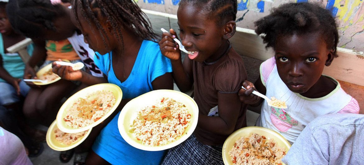 In Haiti, children in the Port-au-Prince slum of Bel Air enjoy a meal.
