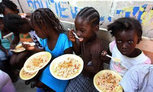 In Haiti, children in the Port-au-Prince slum of Bel Air enjoy a meal.