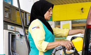 Une femme faisant le plein d'essence en Malaisie. Photo Banque mondiale/Nafise Motlaq