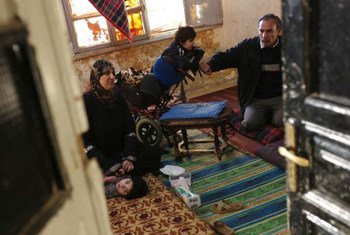 Members of a family gather on the floor of their dilapidated apartment in downtown Amman, Jordan.