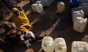 Women wait to collect water in the Nifasha camp for internally displaced persons (IDPs) in Shangil Tobaya, North Darfur.