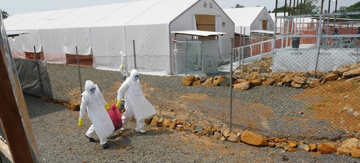 Highly contaminated waste is removed from an Ebola Treatment Unit and carried with caution to a disposal area, where it will be fed into an incinerator that burns it into ashes.
