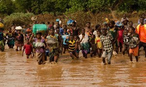 Flood victims rush to a rescue boat of the Malawi Defence Force in Makalanga.