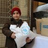 Un enfant récupère de l'aide alimentaire du PAM dans un centre de distribution en Syrie. Photo PAM