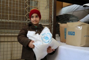 Un enfant récupère de l'aide alimentaire du PAM dans un centre de distribution en Syrie. Photo PAM