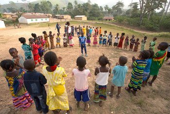 En Guinée, qui a été très touchée par Ebola, des enfants, encadrés par un adulte, jouent dans le village de Meliandou. Photo : UNICEF/Mark Naftalin