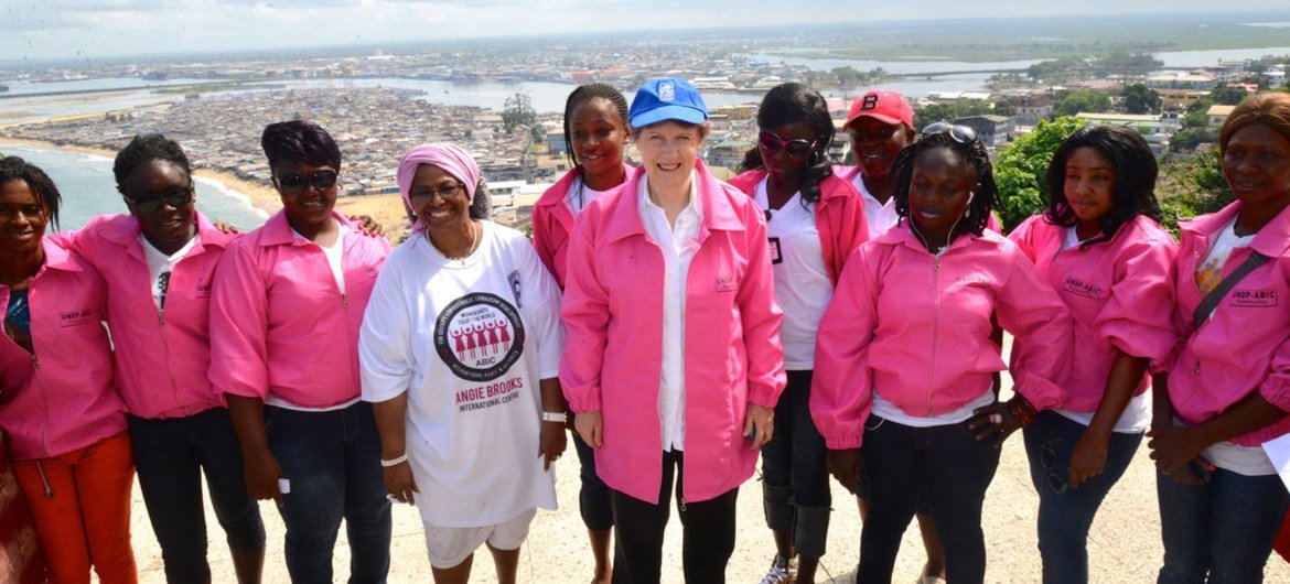 UNDP Administrator Helen Clark (centre), on a visit to Ebola-hit Liberia, is presented with her own pink jacket by members of the “Pink Panthers” motorcycle club, a group of women who ride motorbikes for a living.