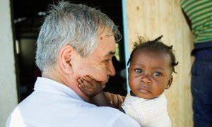 Pedro Medrano Rojas holds a child during a July 2014 visit to the community of Las Palmas, Haiti.