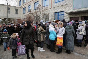 Displaced families and the elderly in Ukraine line up for WFP food vouchers, which enable them to obtain food including milk, fresh fruit, vegetables, eggs and meat.