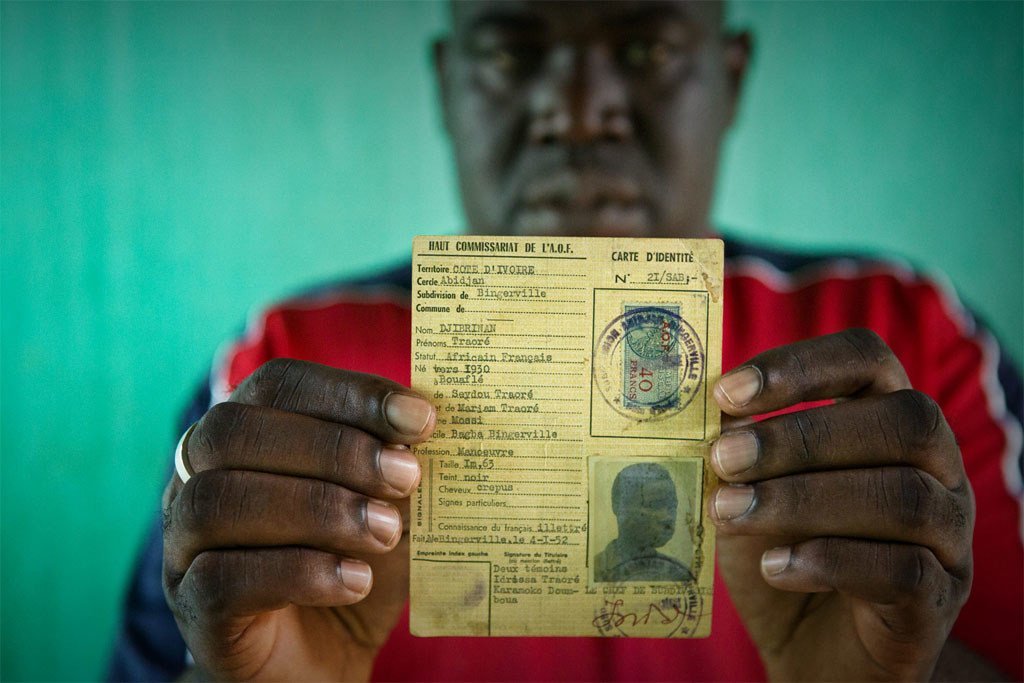 Un homme répondant au nom de Oumar, qui risquait de devenir apatride, brandit la carte d'identité de son père, datant de l'époque coloniale française.
