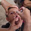 卫生工作者为儿童使用脊灰口服疫苗。世卫组织图片/Wathiq Khuzaie