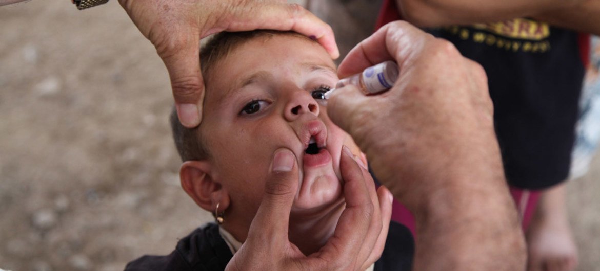 Ребенку дают оральную вакцину от полимомиелита Фото ЮНИСЕФ/Ватик Хузай