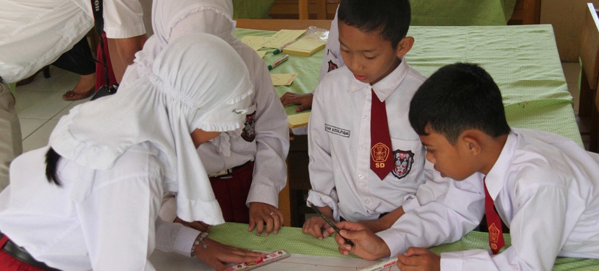 School children in Aceh, Indonesia, work on a risk map as part of community awareness plans to reduce disasters.