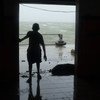 A child looks through a doorway as Cyclone Pam hits Vanuatu, March 2015.