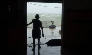 A child looks through a doorway as Cyclone Pam hits Vanuatu, March 2015.