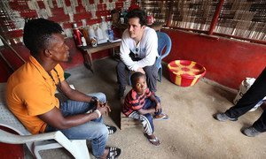 UNICEF Goodwill Ambassador Orlando Bloom (right) talks to a man who lost his wife, two step daughters and infant son to Ebola in Jene Wonde township in Grand Cape Mount County, Liberia.