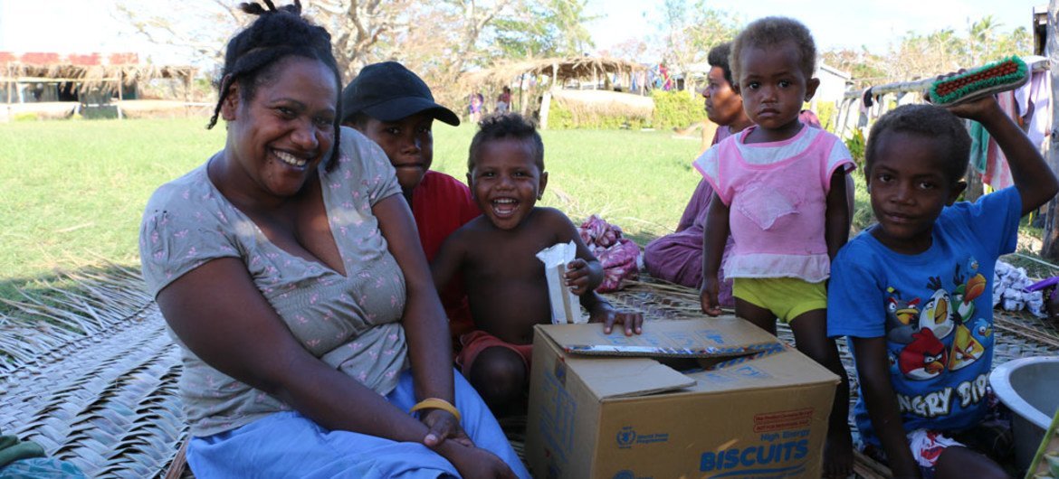 Une famille au Vanuatu recevant de l'aide après le cyclone Pam. Photo PAM/Victoria Cavanagh