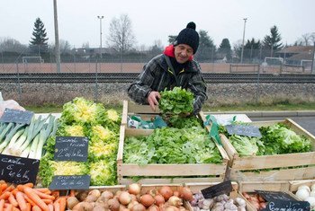 Dans un marché en plein air en Haute-Savoie, en France, un homme vend des légumes produits en respectant les normes recommandées par l'OMS. Photo OMS/V. Martin