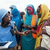 ضابطة الشرطة التنزانية غريس نغاسا (يسار)، التي تعمل مع بعثة يوناميد في دارفور، تتفاعل مع امرأة مقيمة في مخيم زمزم للنازحين، قرب الفاشر، عاصمة شمال دارفور.