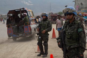 In Cité Soleil, Haiti, Chilean UN Peacekeeping Engineers carry out roadwork as Brazilian Peacekeepers provide security.