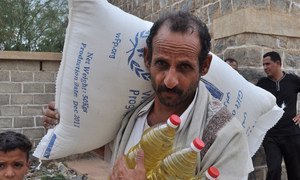 A farmer collects food ration for his family. An estimated 12 million Yemenis are food insecure.