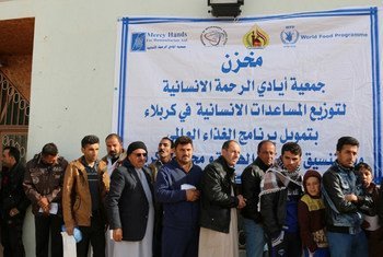 At a distribution center in Kerbala governorate internally displaced Iraqis line up to receive food rations from the World Food Programme distributed by the UN agency’s cooperating partner Mercy Hand.
