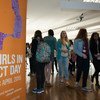 Girls attending a Girls in ICT Day event on April 23, 2015, standing in a hallway next to an orange and purple banner.