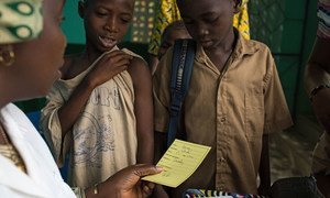 A nurse gives children their vaccination card after having received measles and polio vaccination, as well as deworming pills and Vitamin A supplement at the Madina Health Centre in Guéckédou, Guinea.