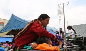A mother tends to her daughter, injured in Nepal's recent earthquake, at the Tribhuvan University Teaching Hospital in Kathmandu. Most patients have been moved outside, as the country experiences continuing aftershocks.
