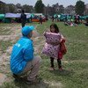 Un trabajador de UNICEF asiste a una niña que busca refugio despues de un terremoto en Nepal  Foto: UNICEF/NYHQ2015-1007/Nybo
