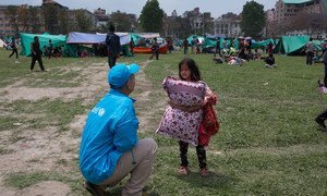 A UNICEF worker speaks to a child seeking temporary shelter at a vacant field next to Nepal's army headquarters in Kathmandu following Nepal's massive earthquake.