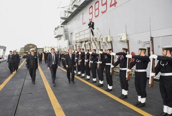 Secretary-General Ban Ki-moon (walking, right) on board the Italian naval vessel, San Giusto, in Sicily.