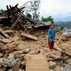 一名八岁尼泊尔儿童站在地震废墟之上。儿基会图片/Karki