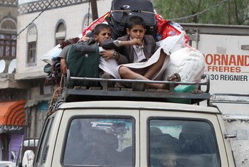 Two boys sit amid belongings on the roof of a vehicle fleeing Sana’a, the capital of Yemen.