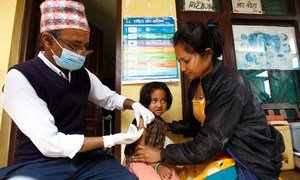 Un travailleur de santé vaccine un enfant de quatre ans contre la rougeole dans le village de Bungamati, au Népal. Photo UNICEF/Panday