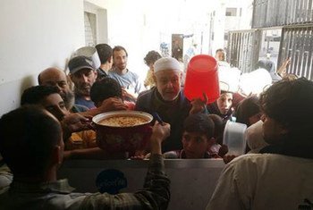 Des civils déplacés de Yarmouk attendent de recevoir un repas chaud à Yalda, en Syrie. Photo UNRWA