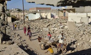 Children play as a donkey cart passes destroyed buildings in the Al-Ora's neighbourhood of Zinjibar, Yemen.