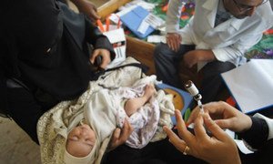 A displaced mother in Sana’a, Yemen, gets her newborn child vaccinated.