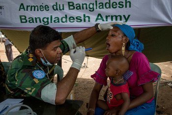 A UN peacekeeper from the Bangladesh Transport Platoon provides free medical consultations to residents of a poor community in Bamako, Mali.