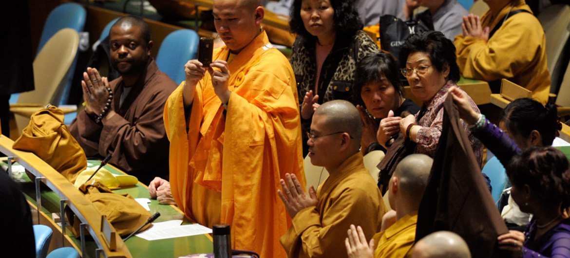 Un moine bouddhiste prend des photos lors d'un événement spécial de l'ONU pour la Journée du Vesak, qui célébre la naissance de Bouddha, à l'Assemblée générale, en mai 2011. Photo : ONU / Evan Schneider