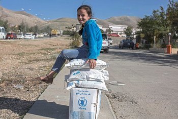 طفلة بالغة من العمر سبع سنوات تحرس معونة أسرتها من برنامج الأغذية العالمي، في السليمانية، العراق. المصدر: مكتب تنسيق الشؤون الإنسانية / ياسون أثانسياديس