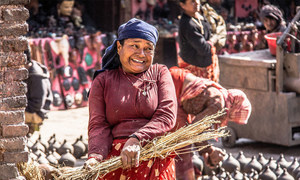 A woman in front of traditional pottery in Kathmandu's Durbar Square.