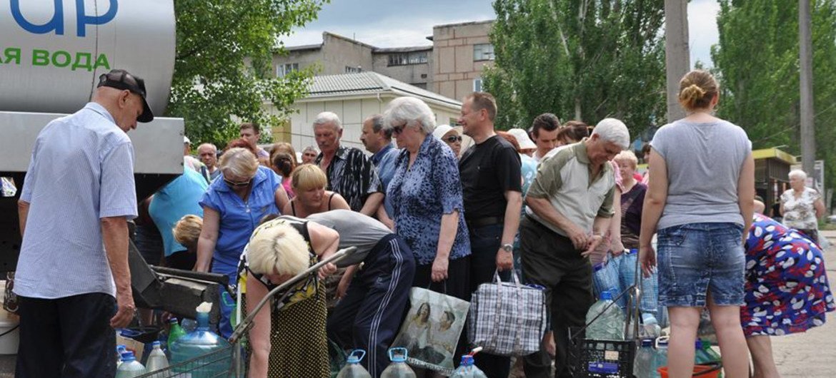 受冲突影响的卢甘斯克居民领取饮用水。联合国儿基会图片。