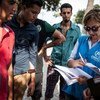 UNHCR staffer helps refugees and migrants to register at the local police station on Kos Island in Greece.
